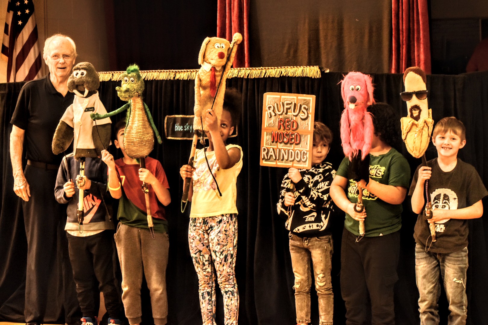 students on stage with puppets
