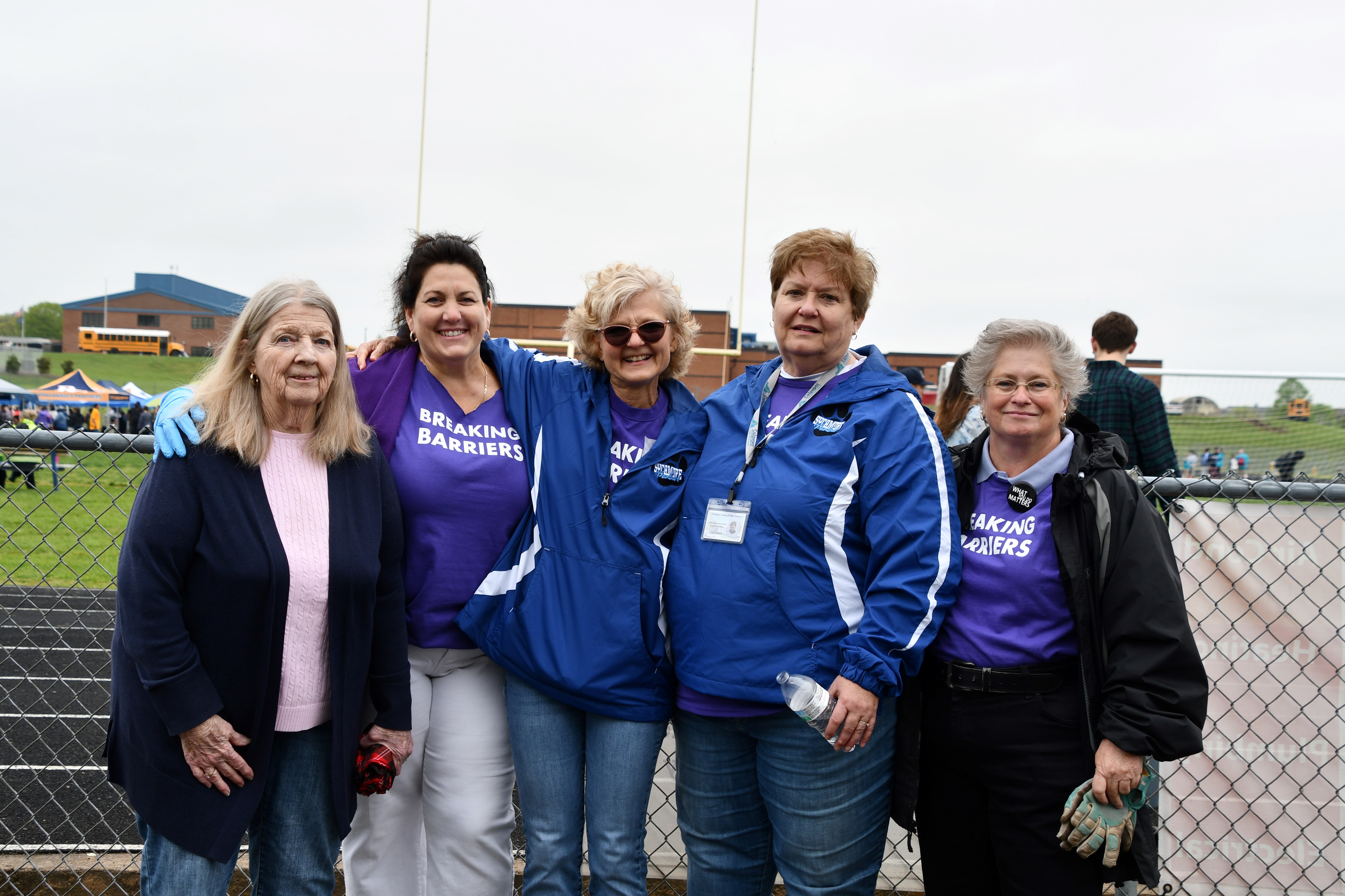 group of ladies standing next to football field