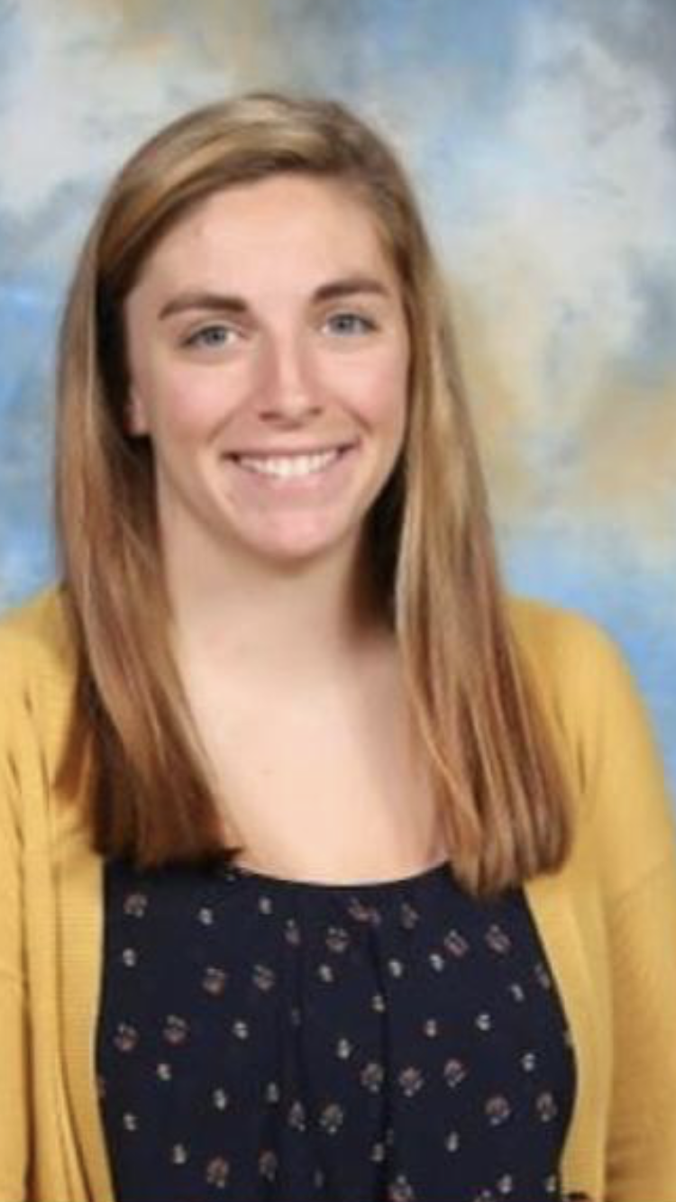 Mrs. Games in a yellow cardigan smiling