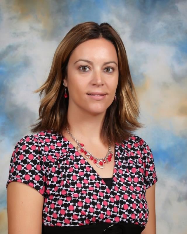 Woman wearing red and blue patterned blouse and red necklace