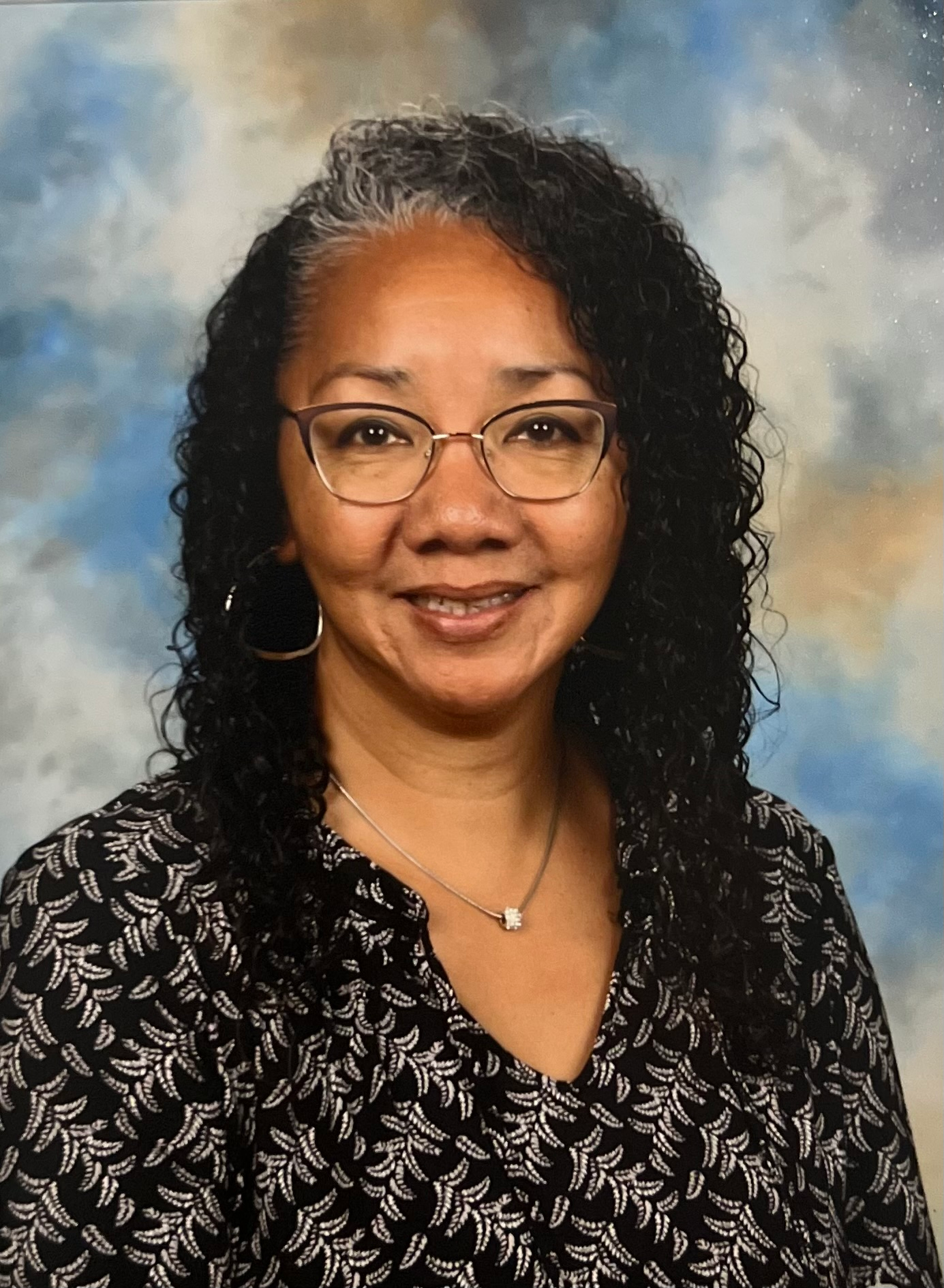 Smiling woman wearing red sweater in front of gray background
