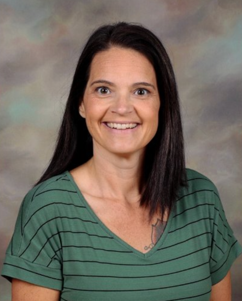 Woman wearing black sweater in front of a gray background 