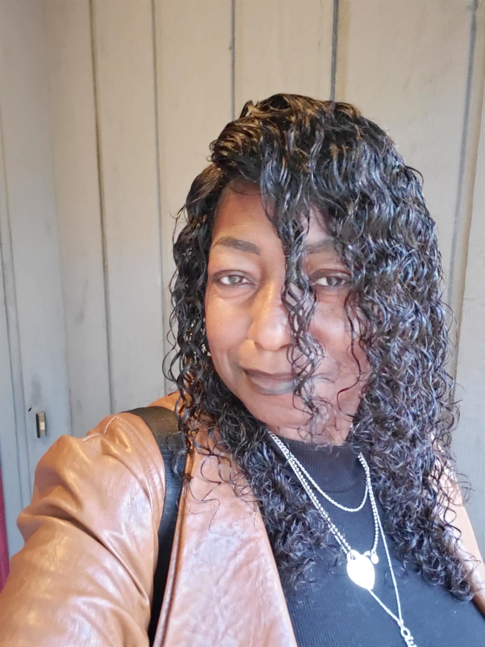 Woman wearing brown jacket and black shirt