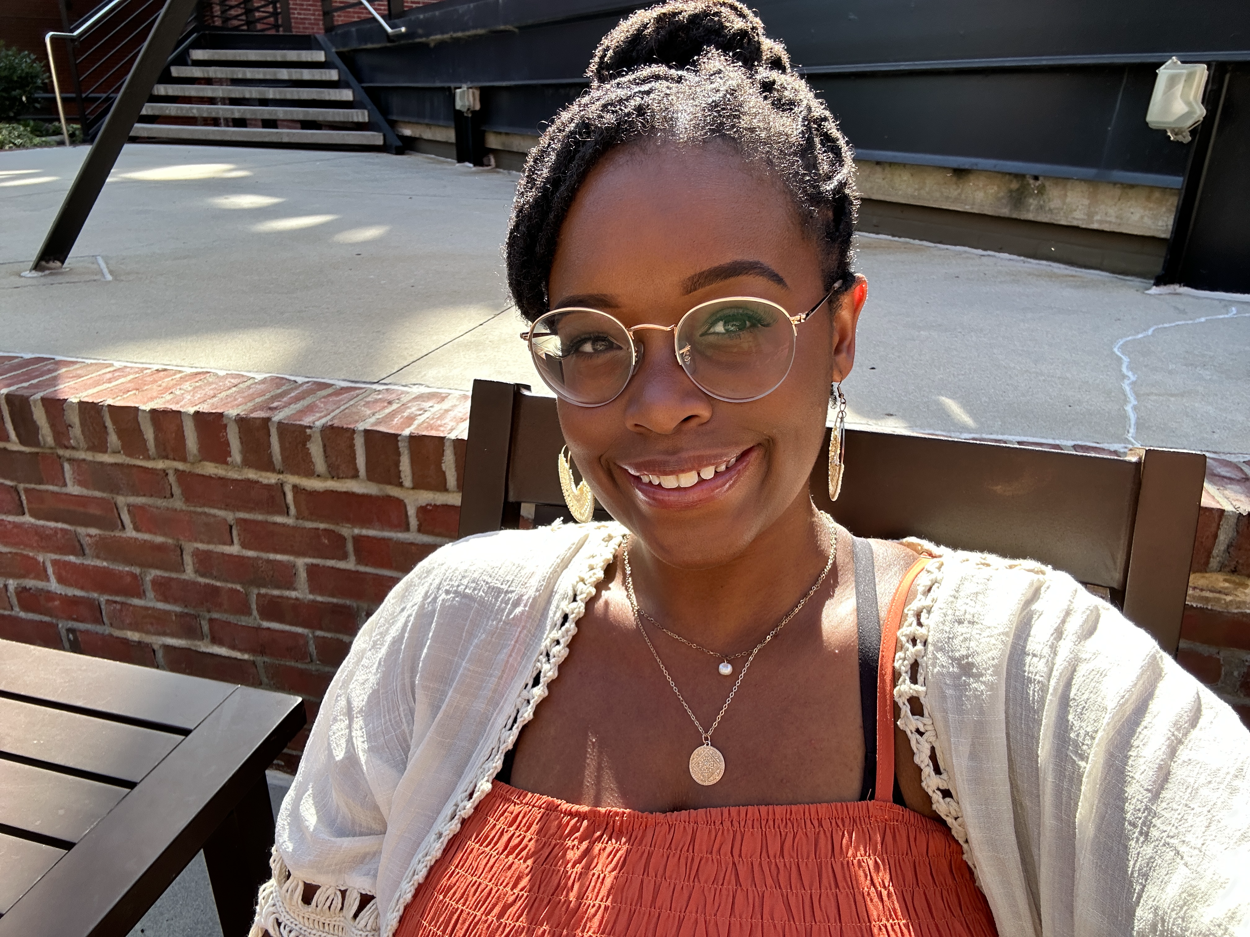 Smiling woman wearing cream colored top and glasses