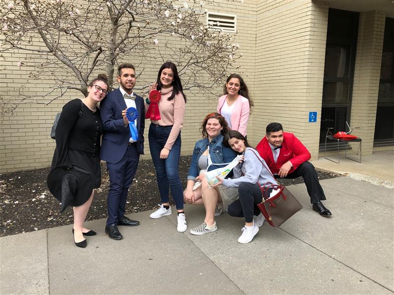 students outside at a chorus competition; students holding up awards 