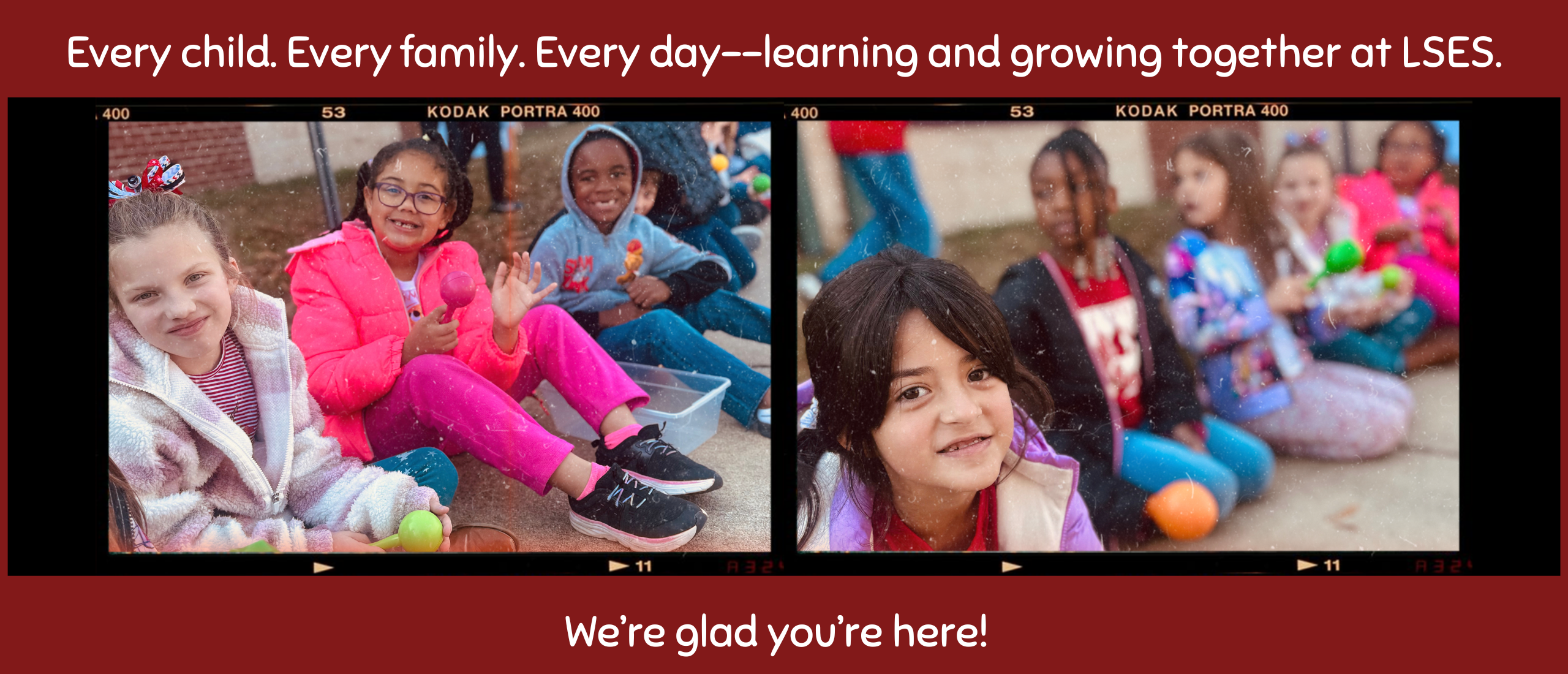 Smiling students sit outside of the school.