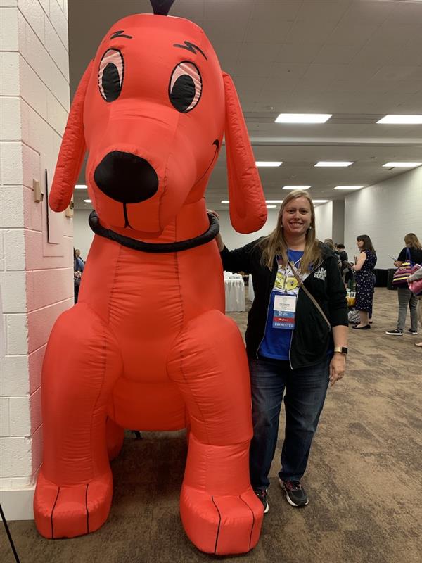 Mrs. Denning posing with a blow-up Clifford the Big Red Dog
