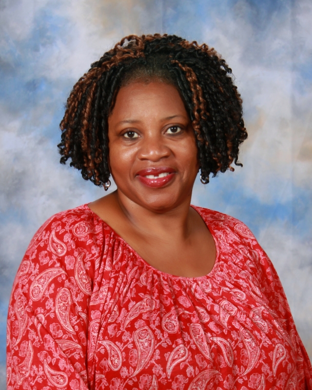 Woman with highlights smiling in a red blouse