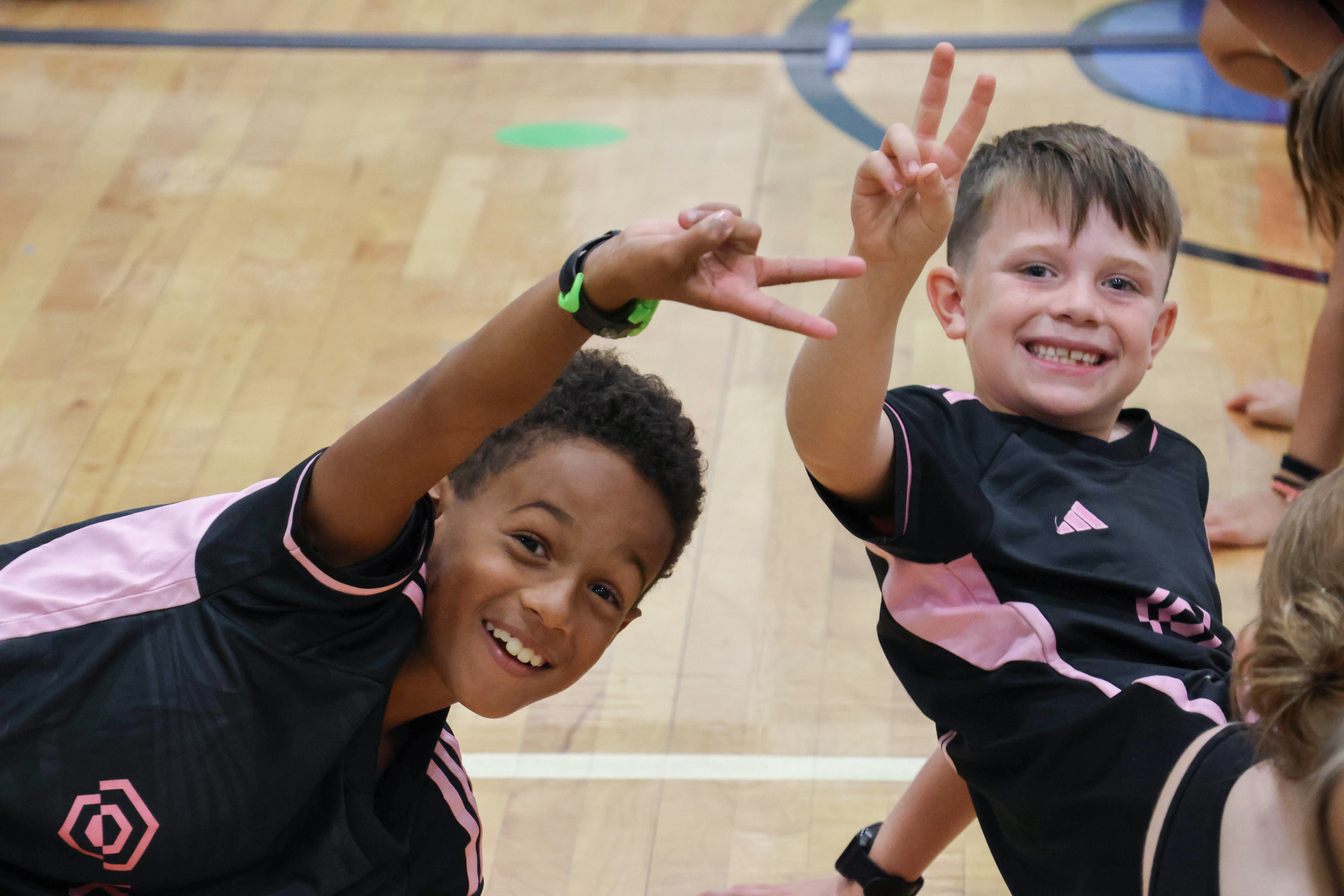 two boys smiling holding up peace signs