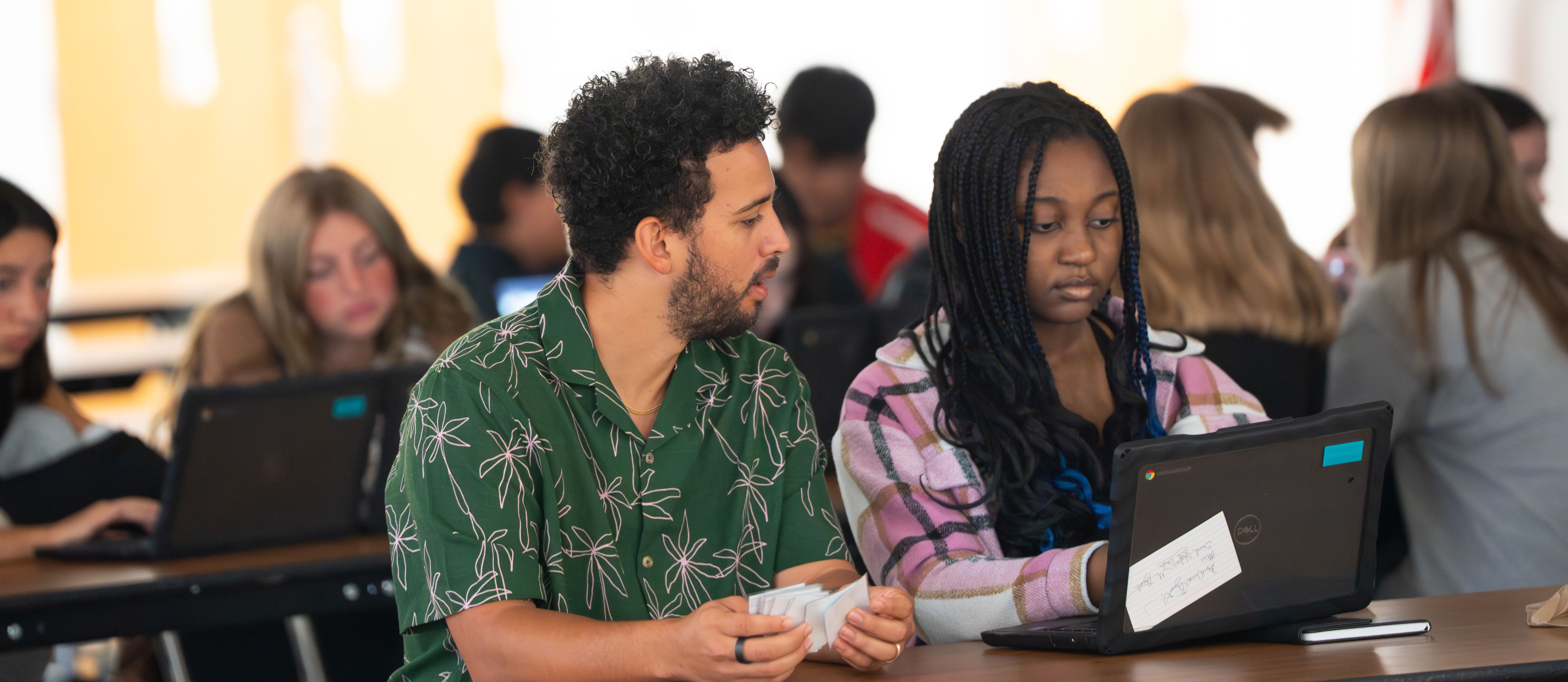 student and teacher looking at a computer