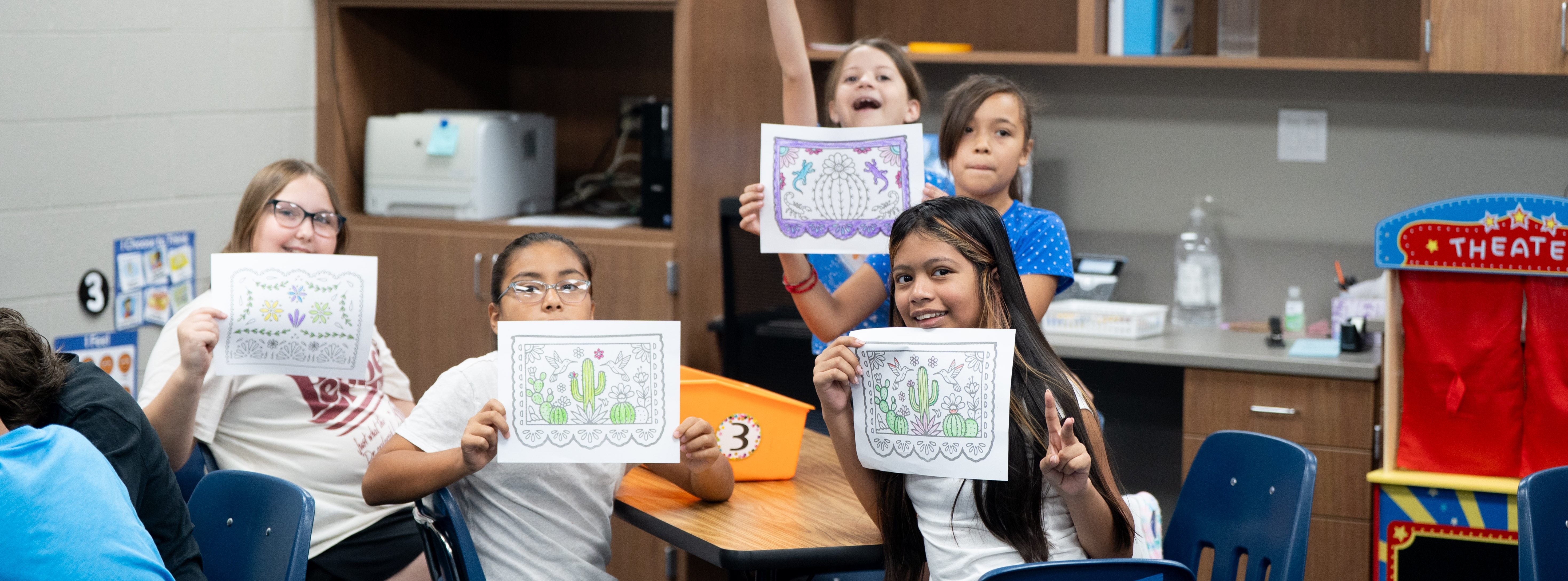 Students holding up artwork