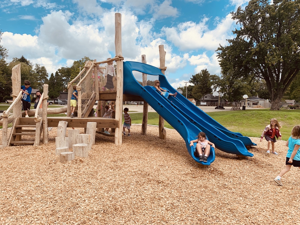 Students playing on slide and other playground equipment