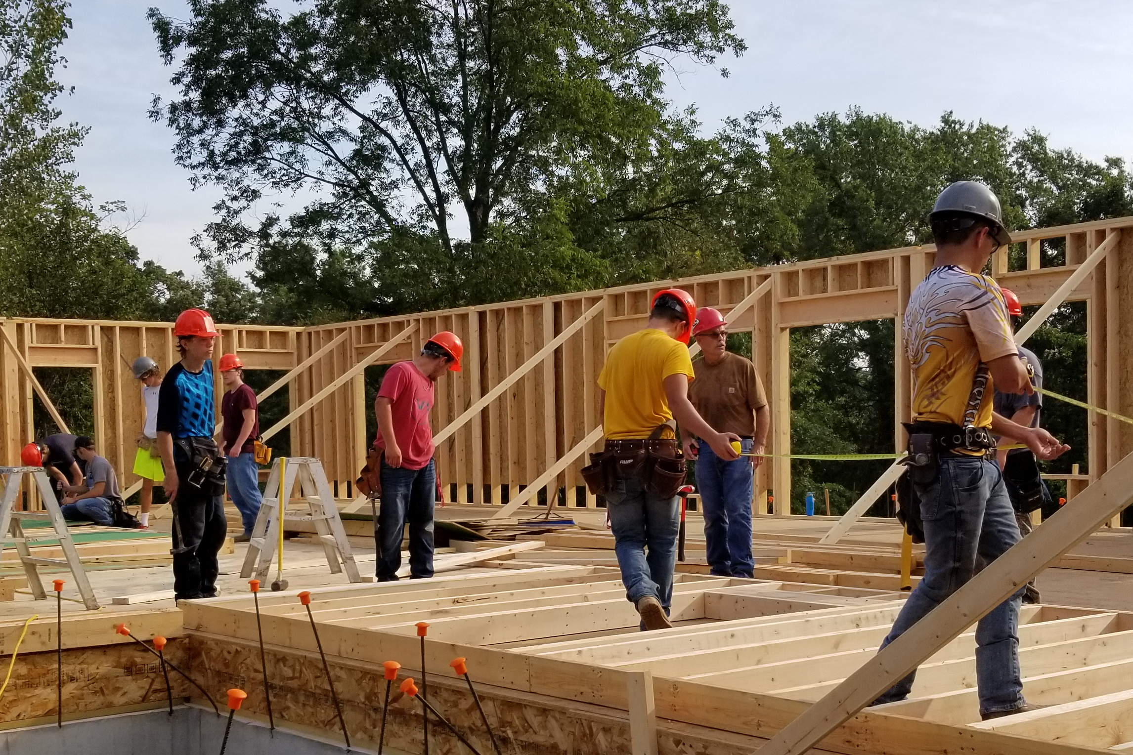 Building Trades students work on building the walls and floor of a new home