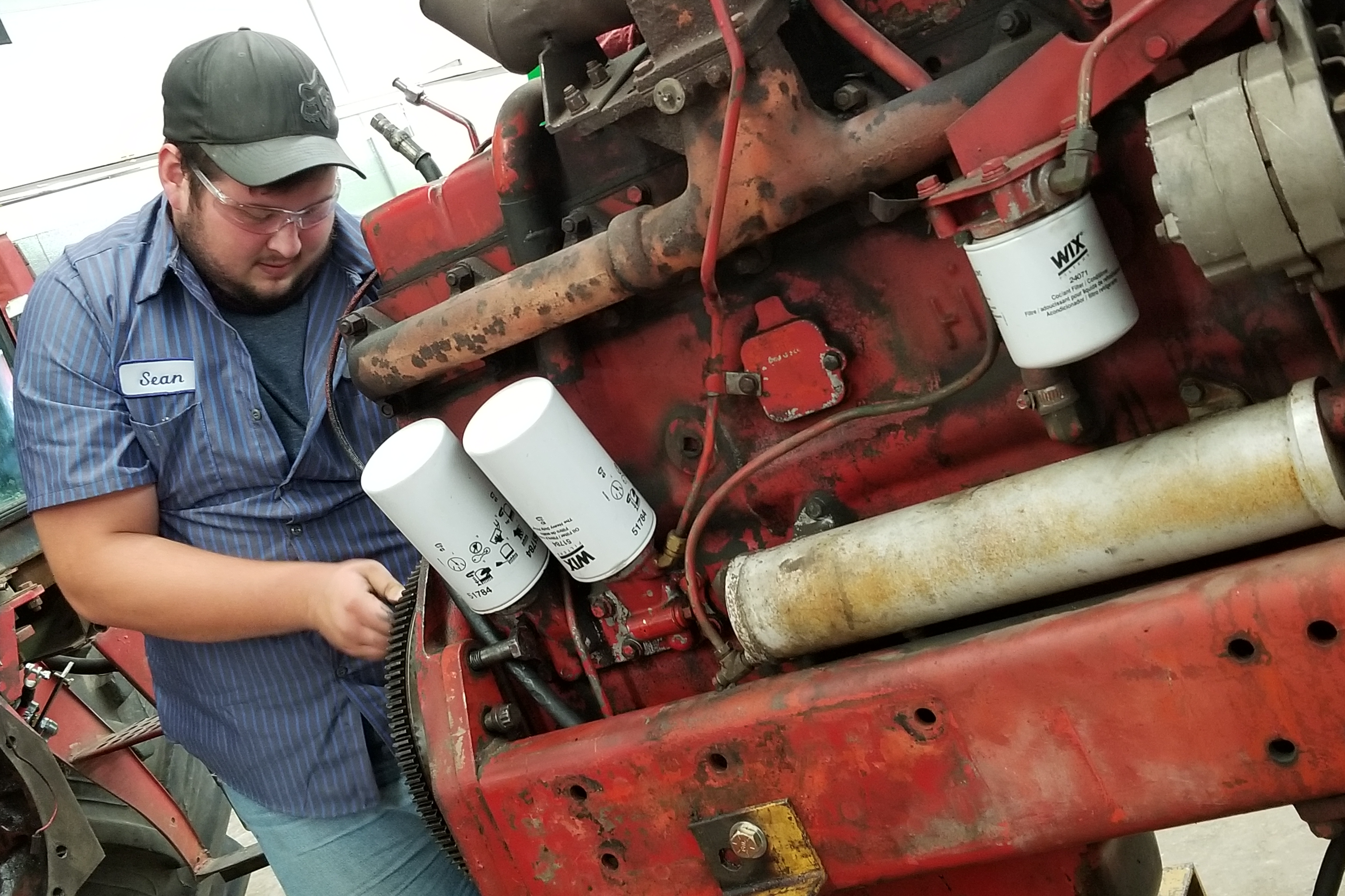 Advanced Diesel Technology student works on a diesel tractor for a community member