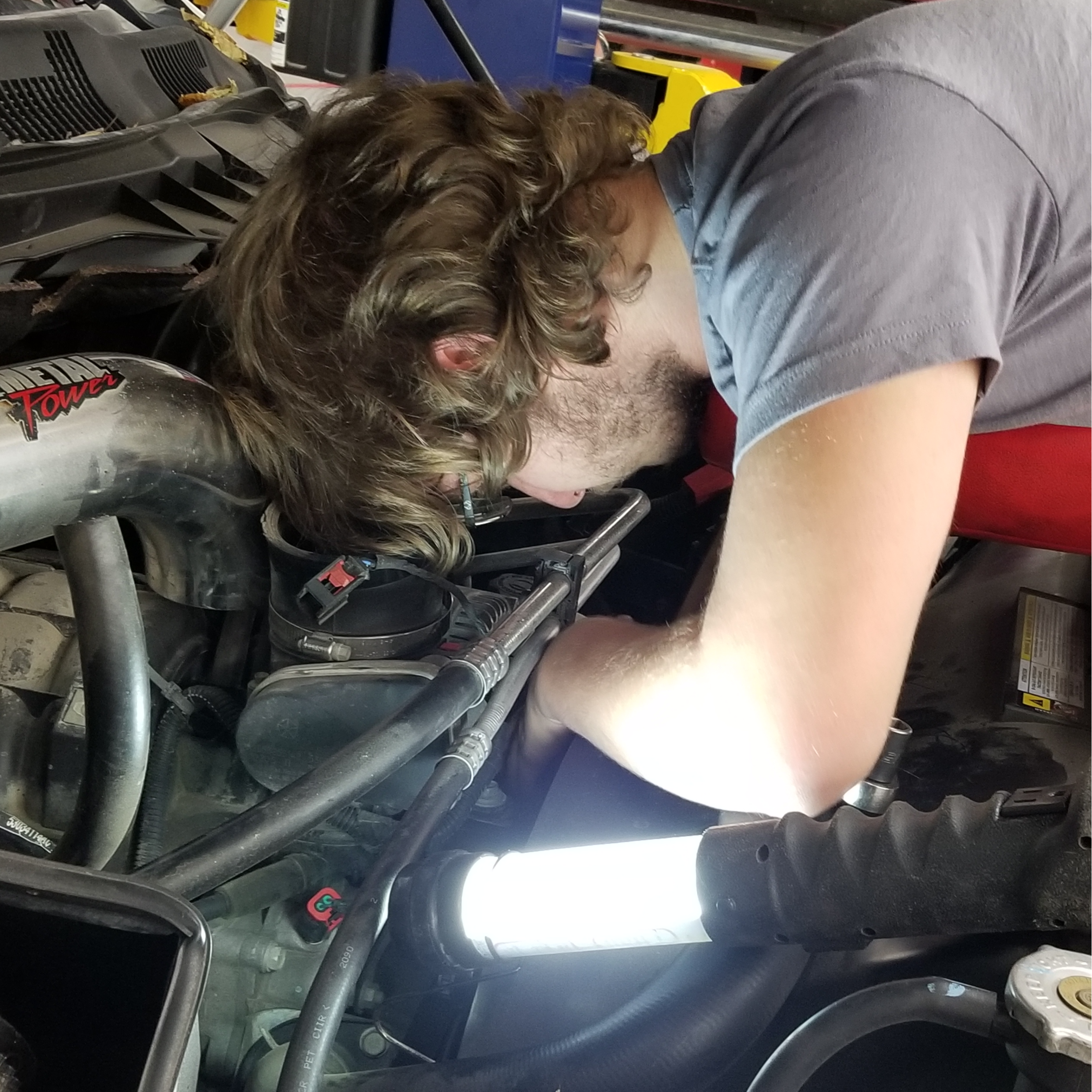 student working on vehicle engine 