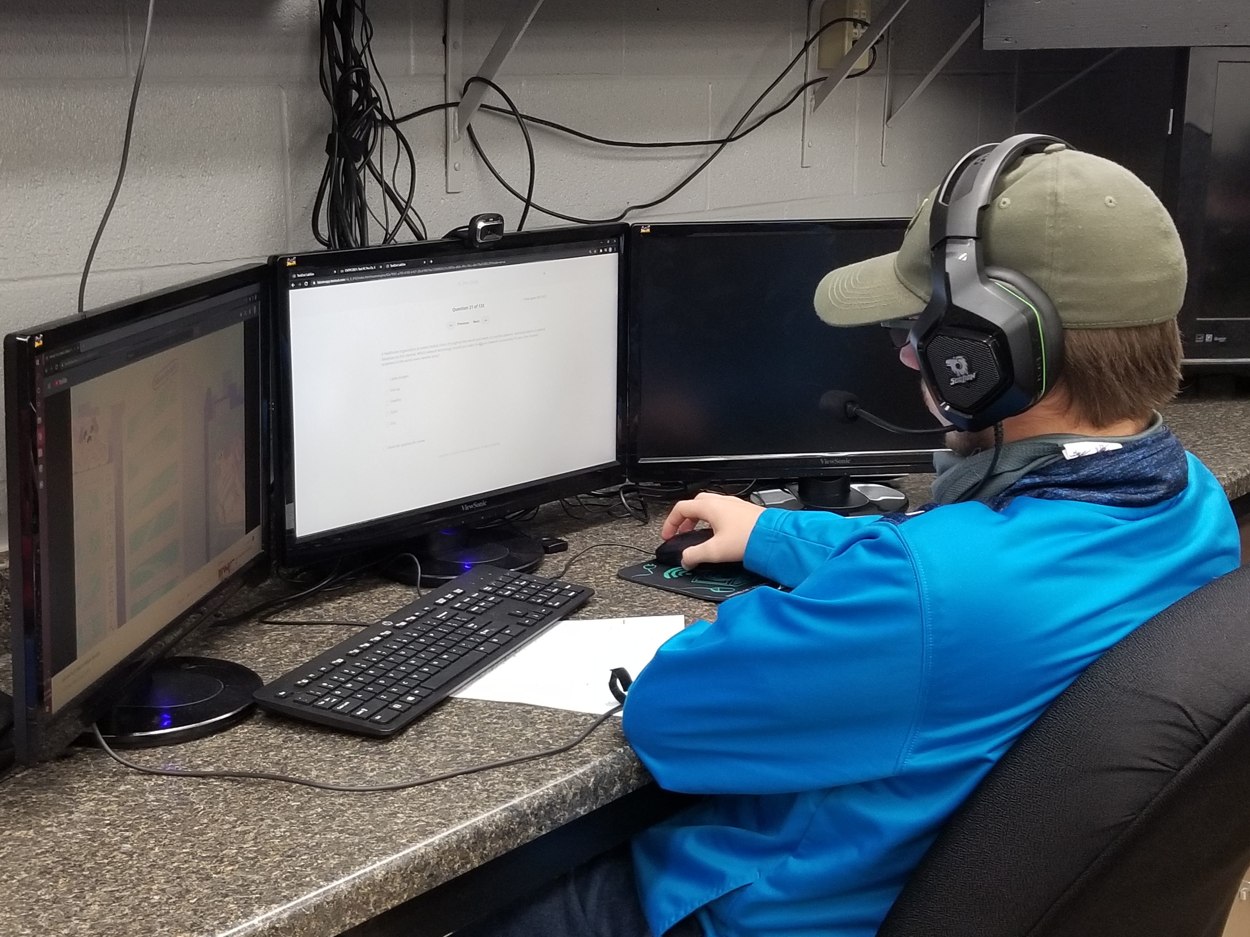 student works on programming skills on three computer screens