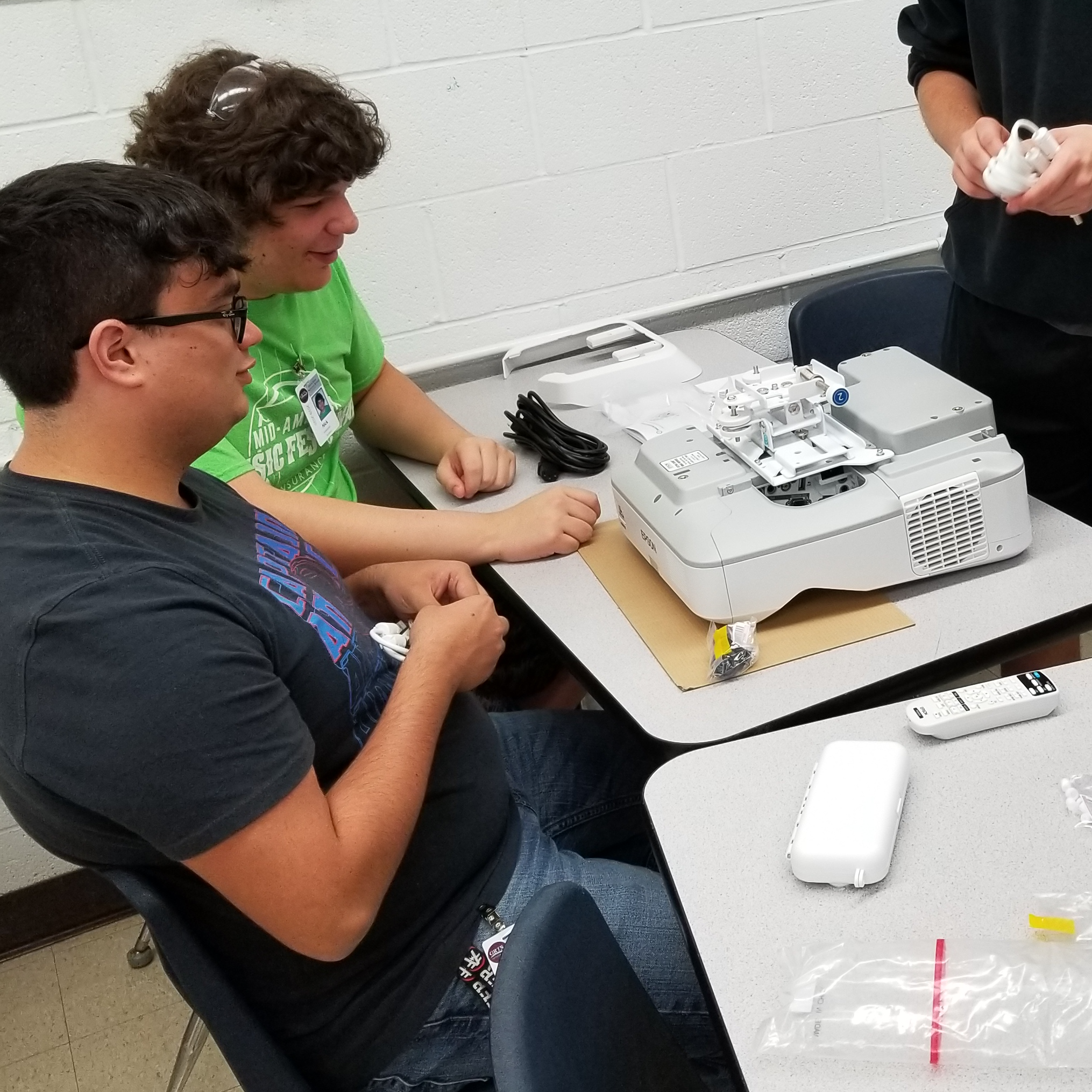 students organize installation of projector in classroom