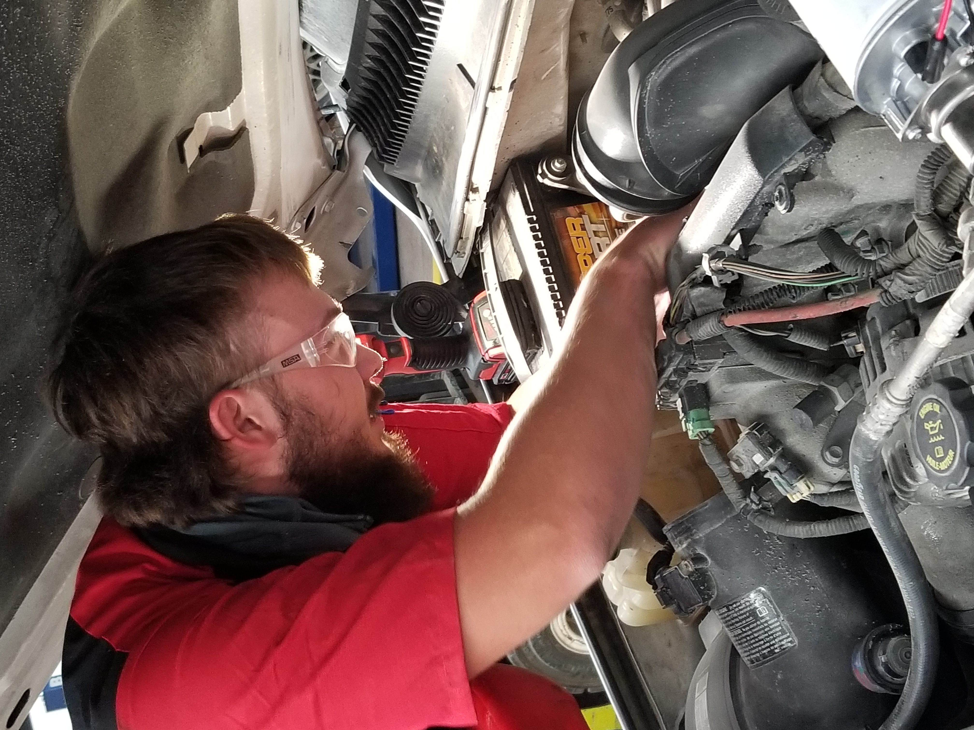 student works on a diesel pick up motor