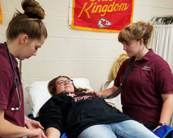 Health Services students practice taking patient vitals