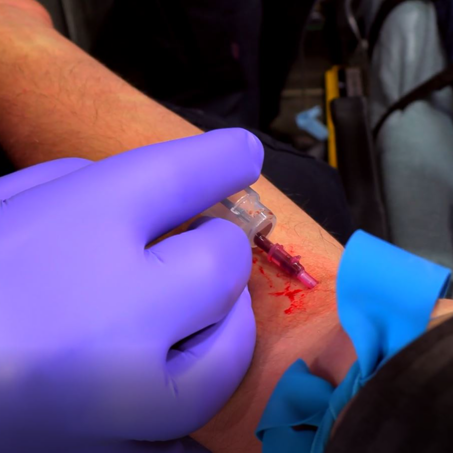 EMS student practices inserting an iv into a patients arm