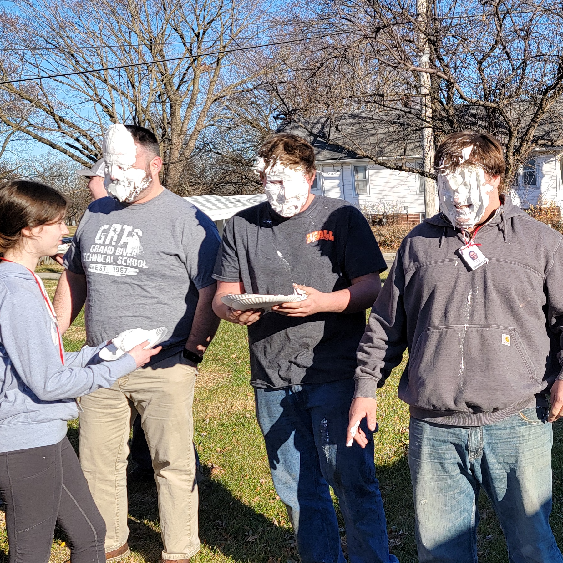 SkillsUSA advisor and two officers receiving  a plate of whip cream in the face as part of their fundraising