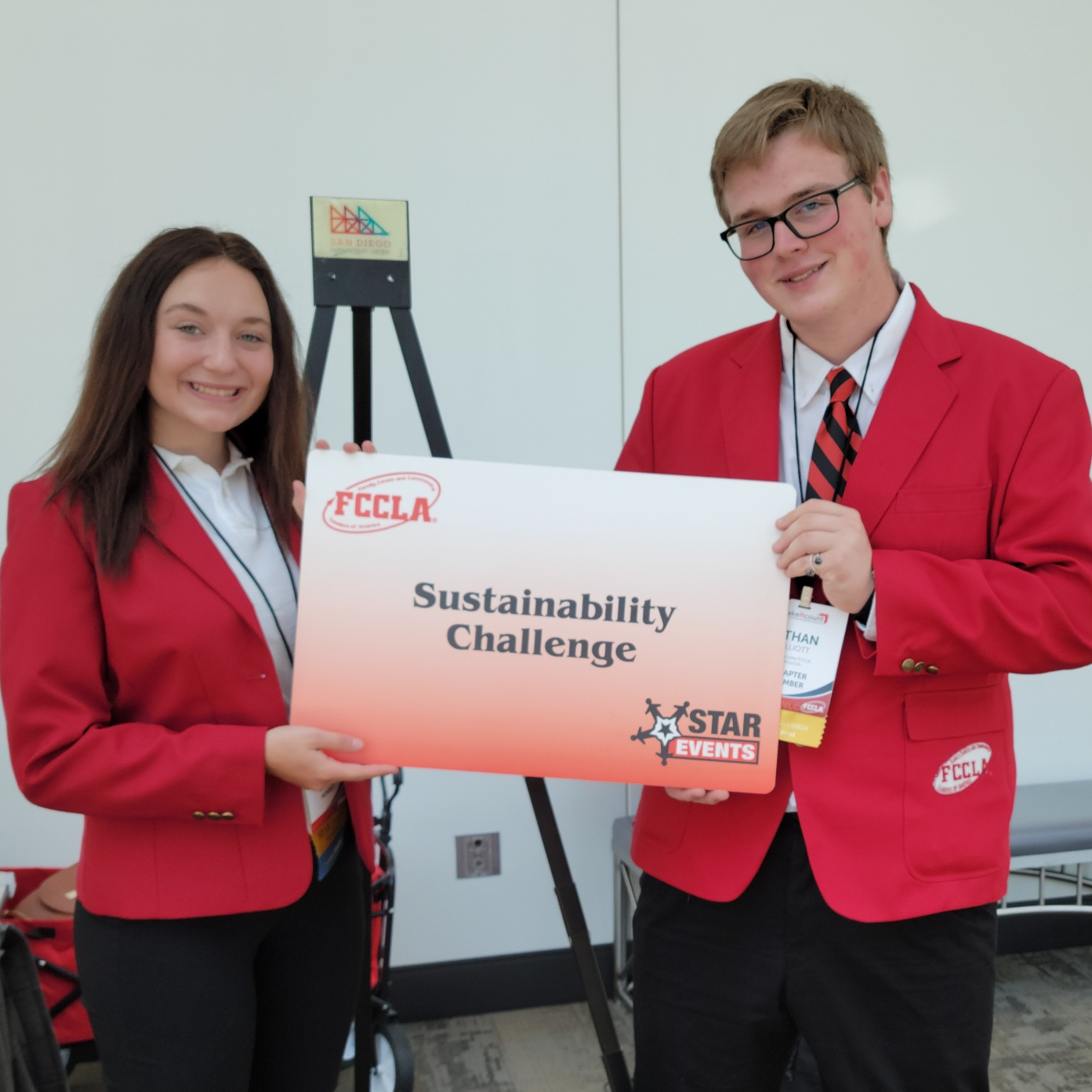 fccla member poses with sustainability challenge poster
