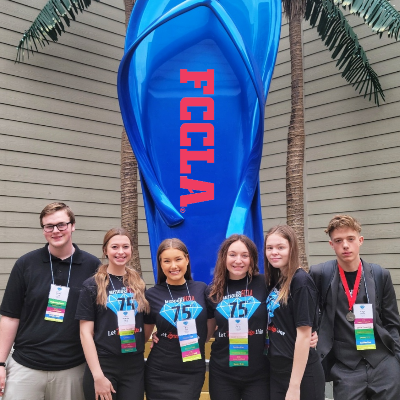 student pose with large blue flip flop at state fccla competition