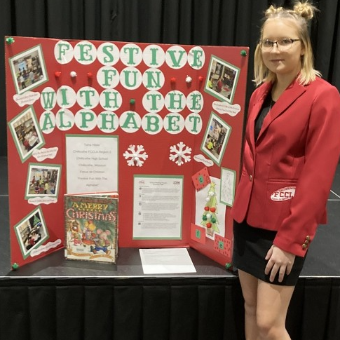 early childhood professions student poses with her presentation for fccla competition