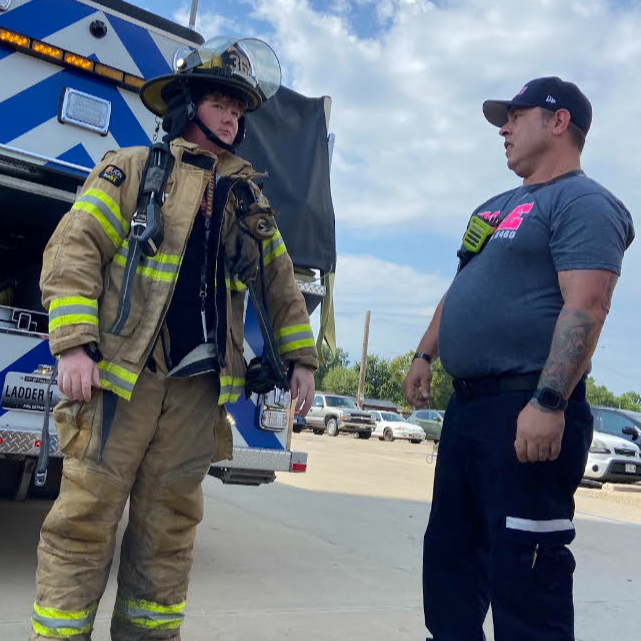 Health Services  tries on firefighter uniform