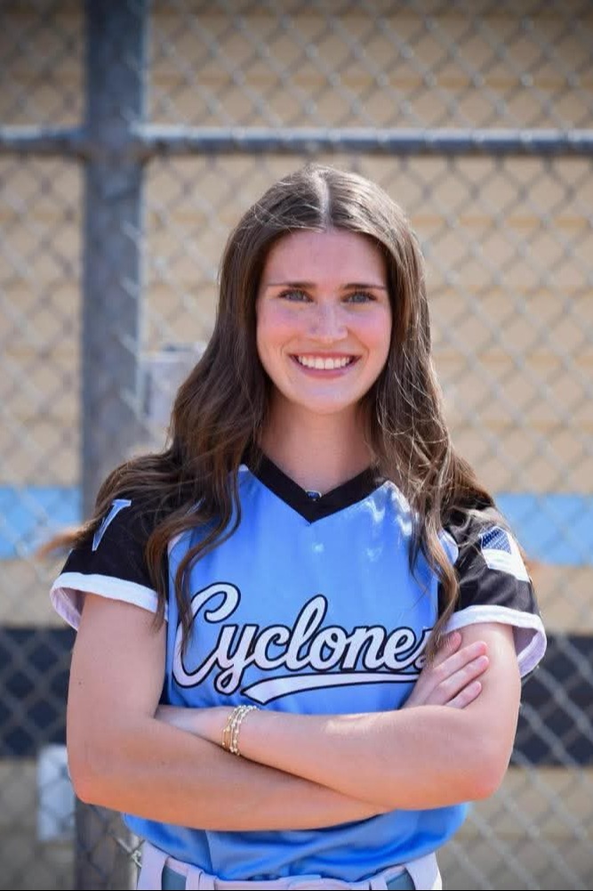 Woman with arms crossed, wearing a blue jersey with white trim and "Cyclone" on the front.
