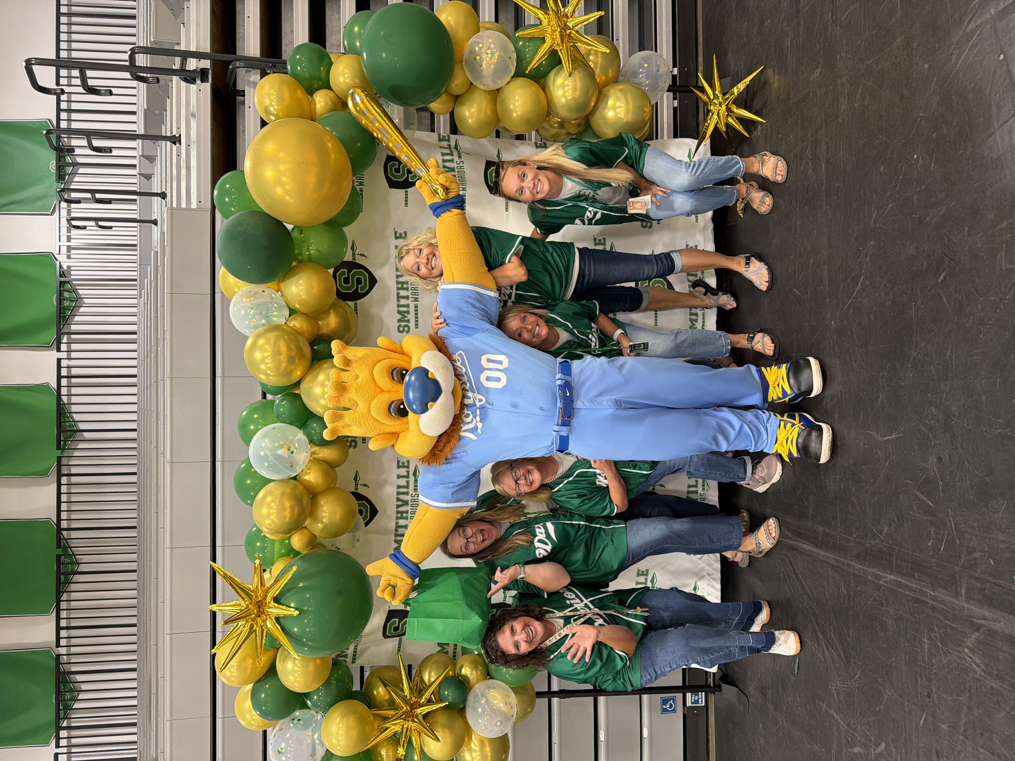 The parents as teachers staff pose for a picture with Slugger, the Royals mascot.