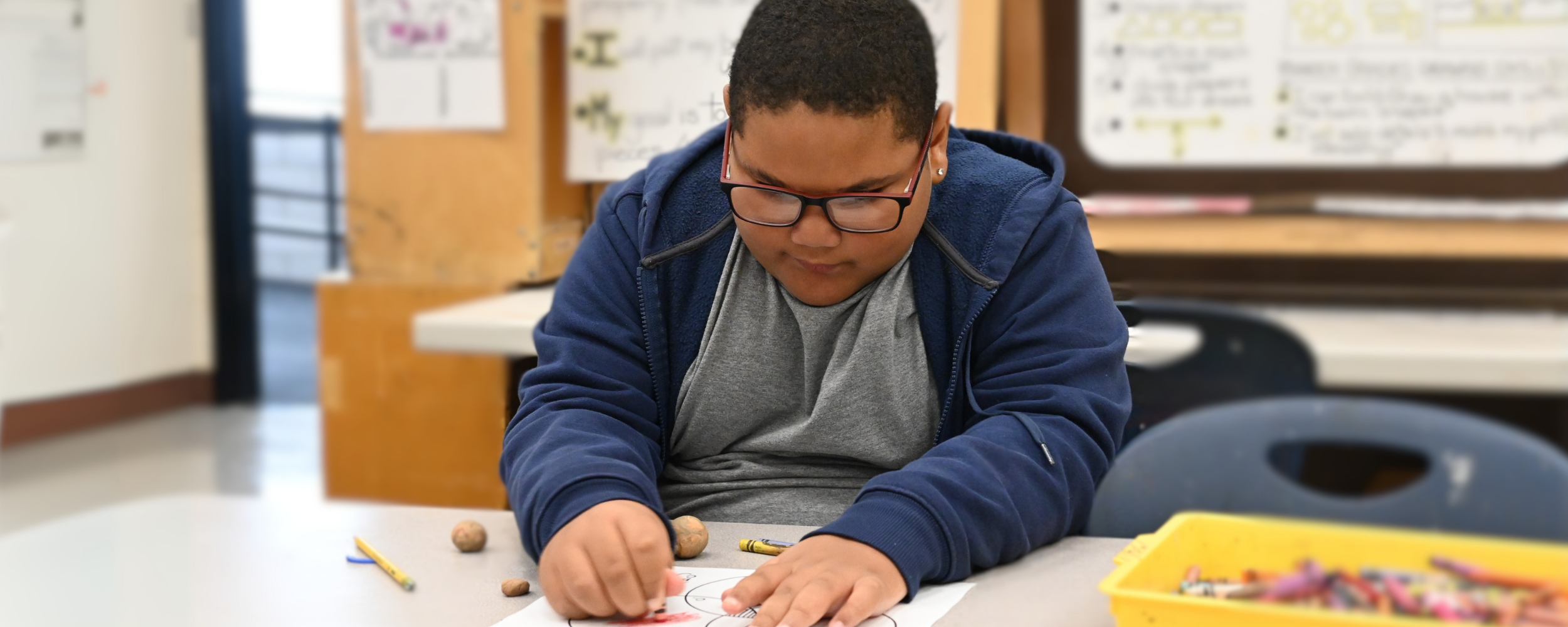 A student in art class considers his project