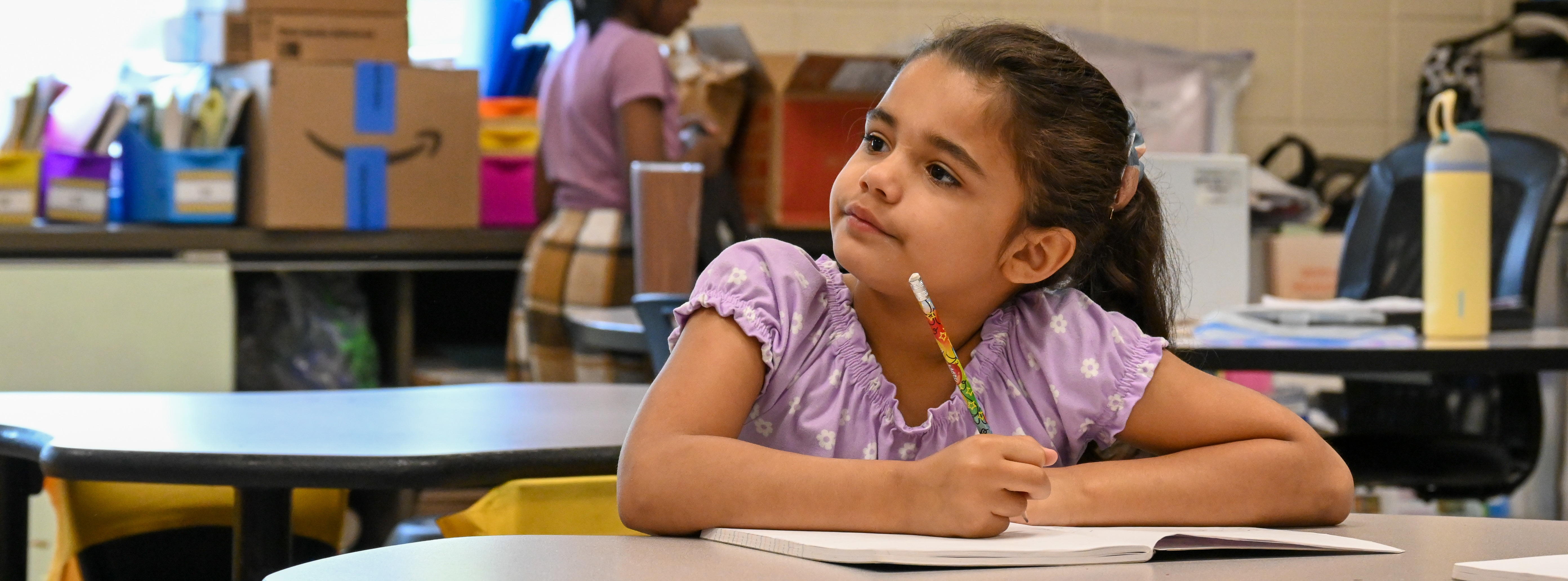student sitting at table writing in notebook