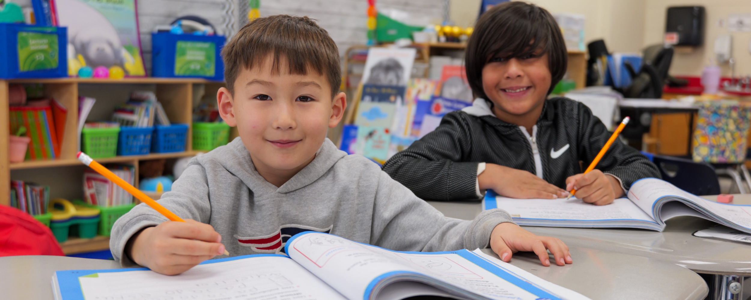 Two students look up from their work books