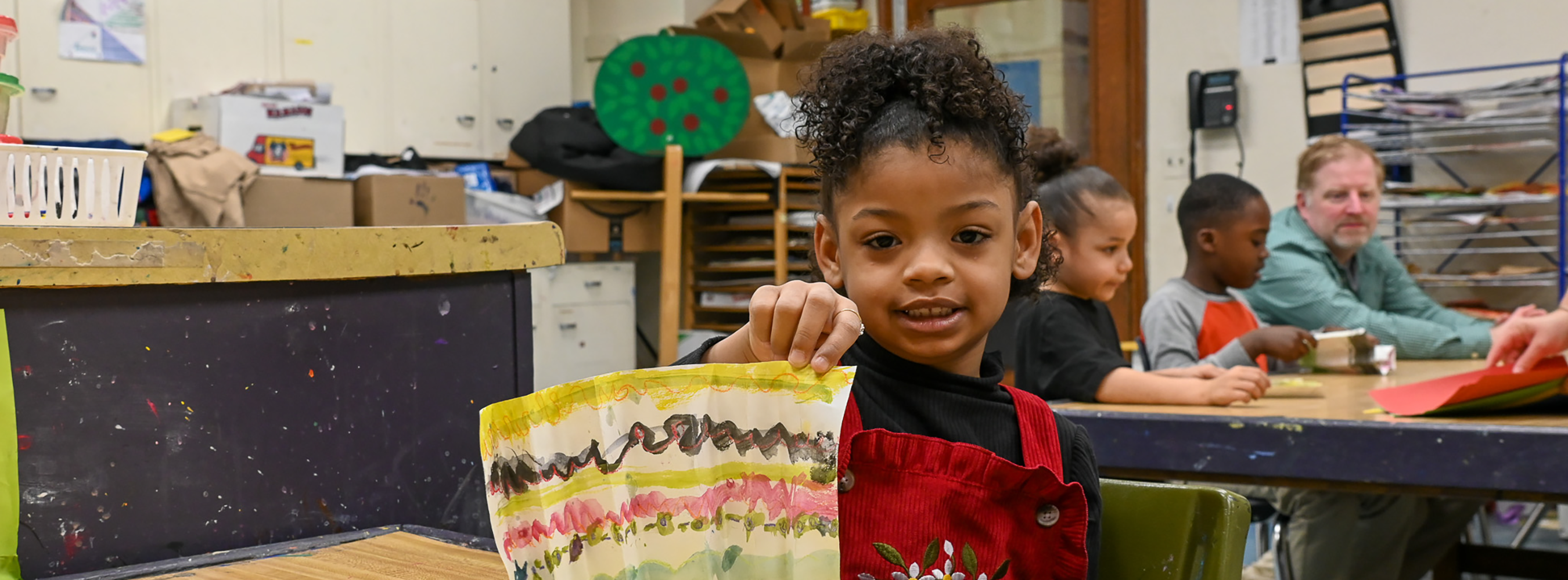 A student shows her art project to the camera