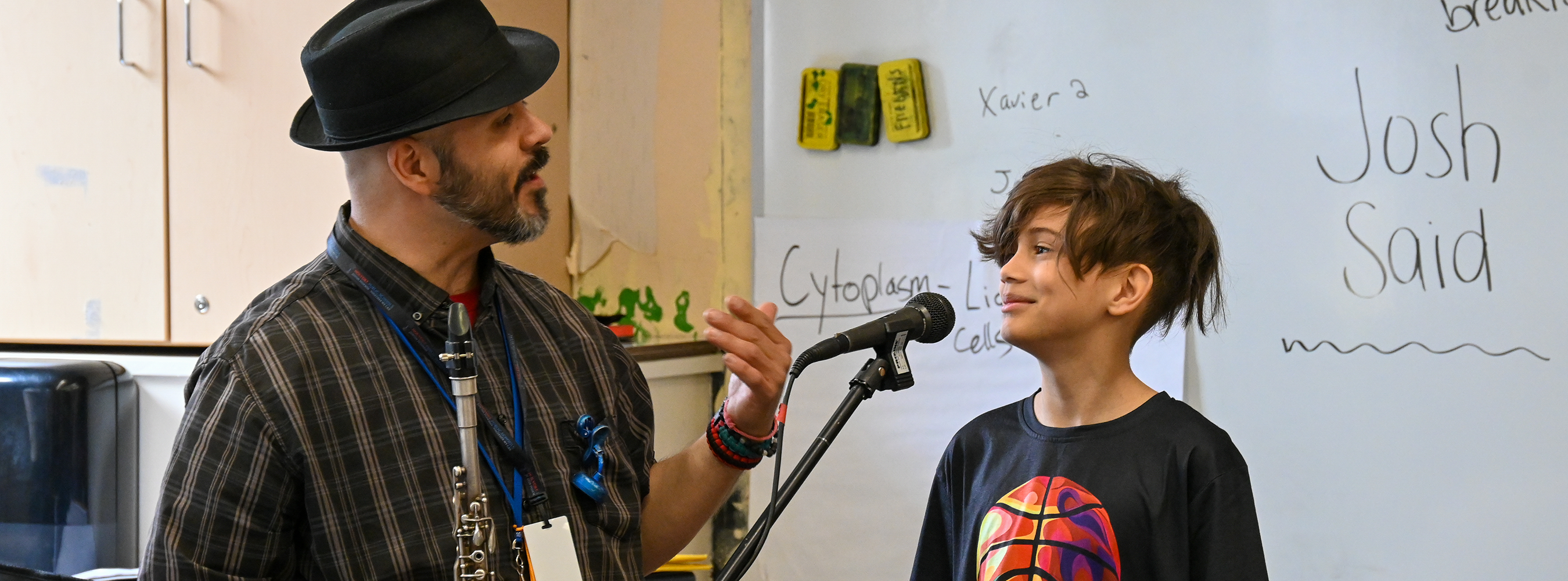 Music teacher talks to student at a microphone