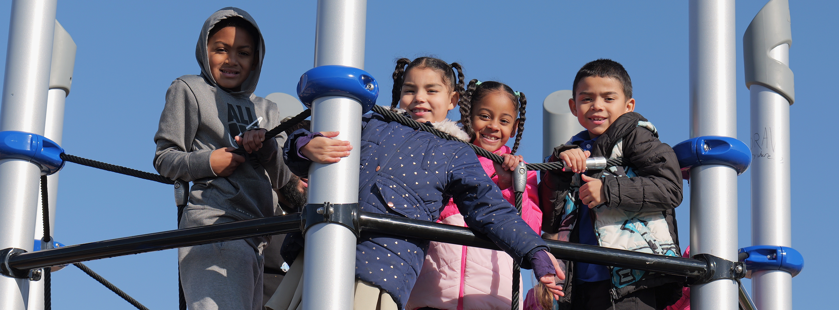 Children standing at top of playground equipment