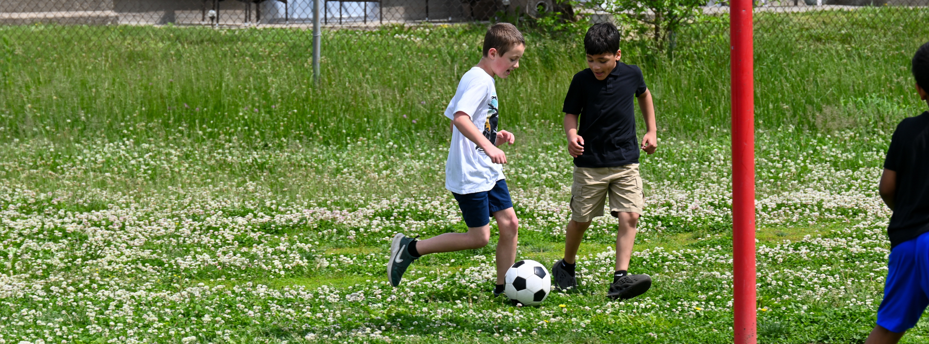 boys playing soccer in a field during gym class