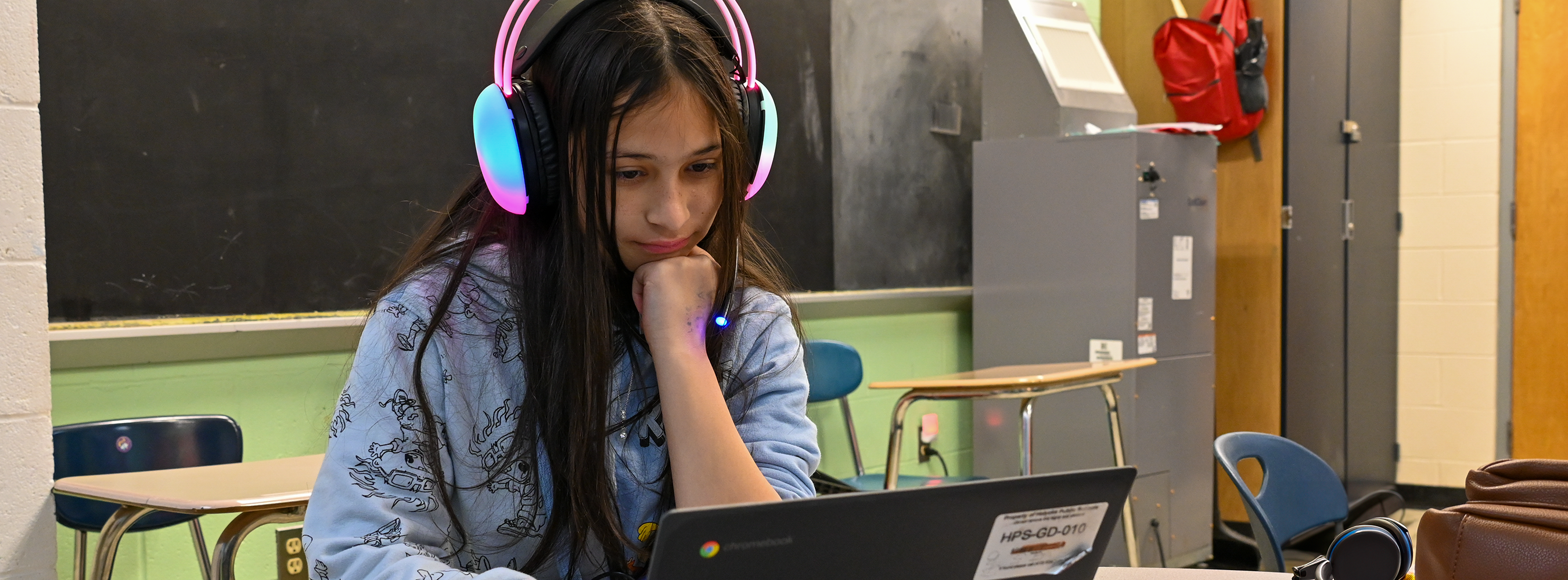 Girl in headphones works on computer