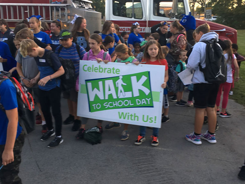 children holding a sign that says walk to school day