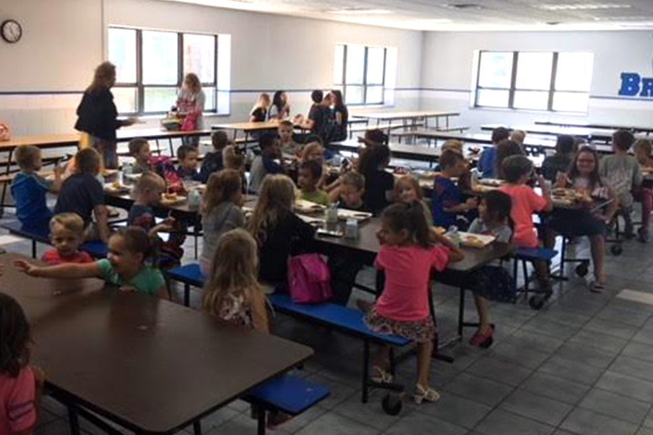 children sitting at tables in the lunch room