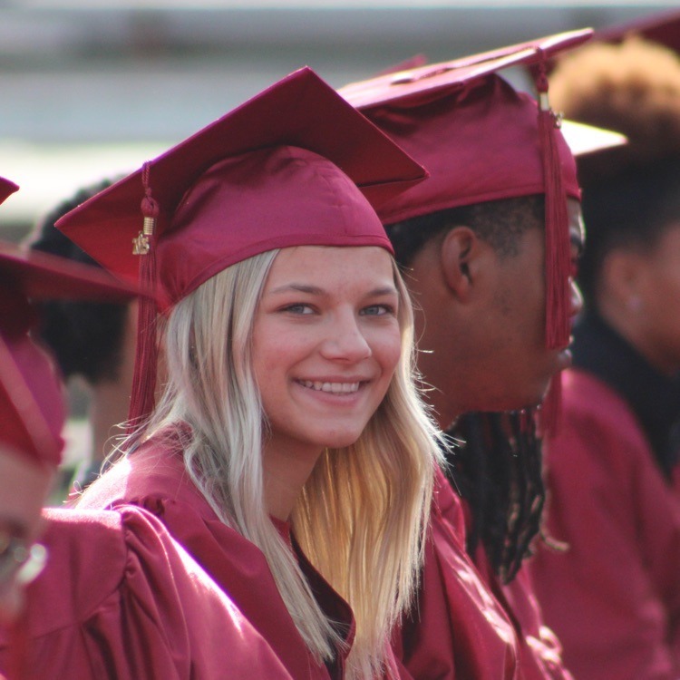 girl in cap and gown smiles