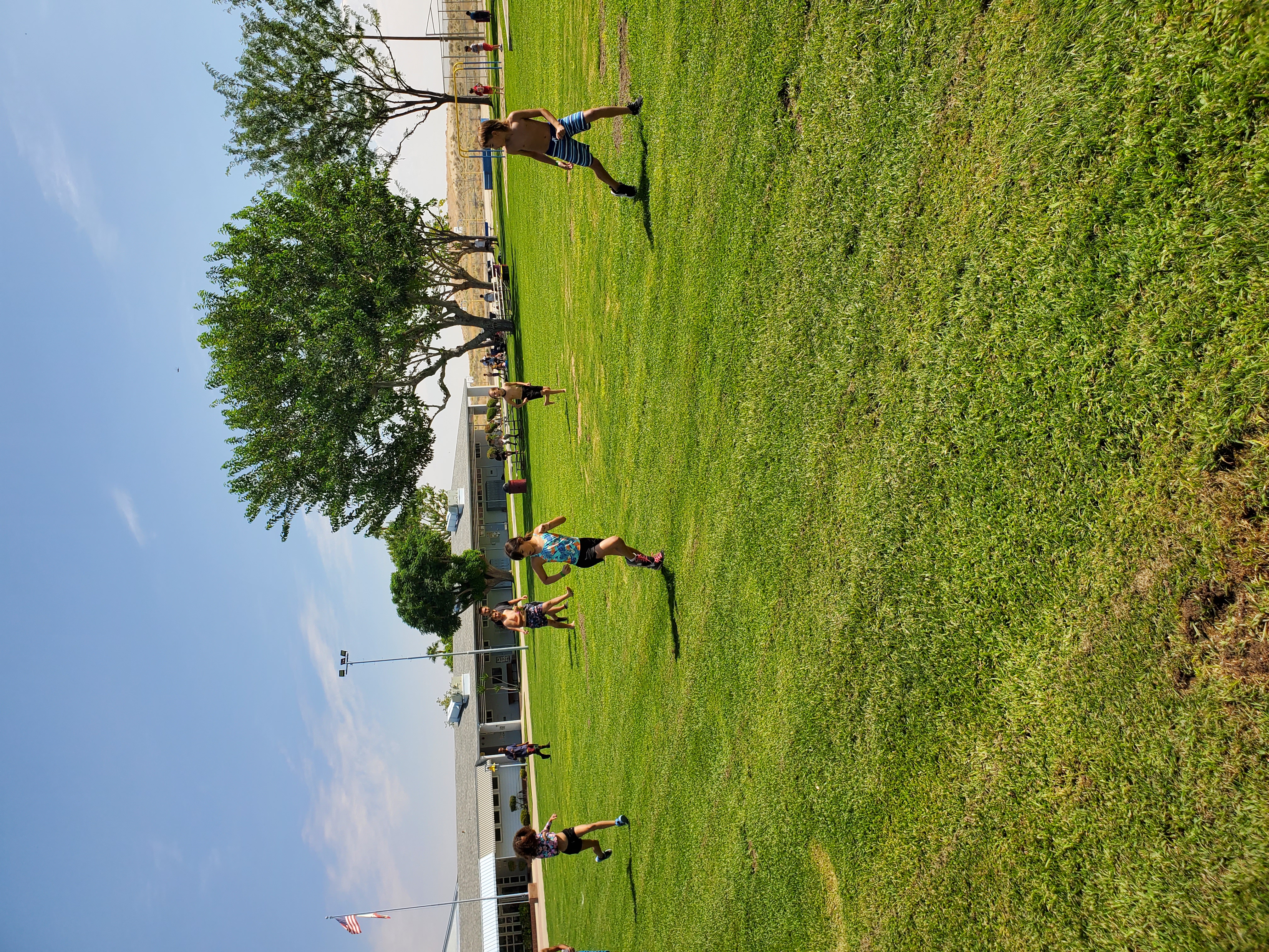 Students competing in a running event on grass field