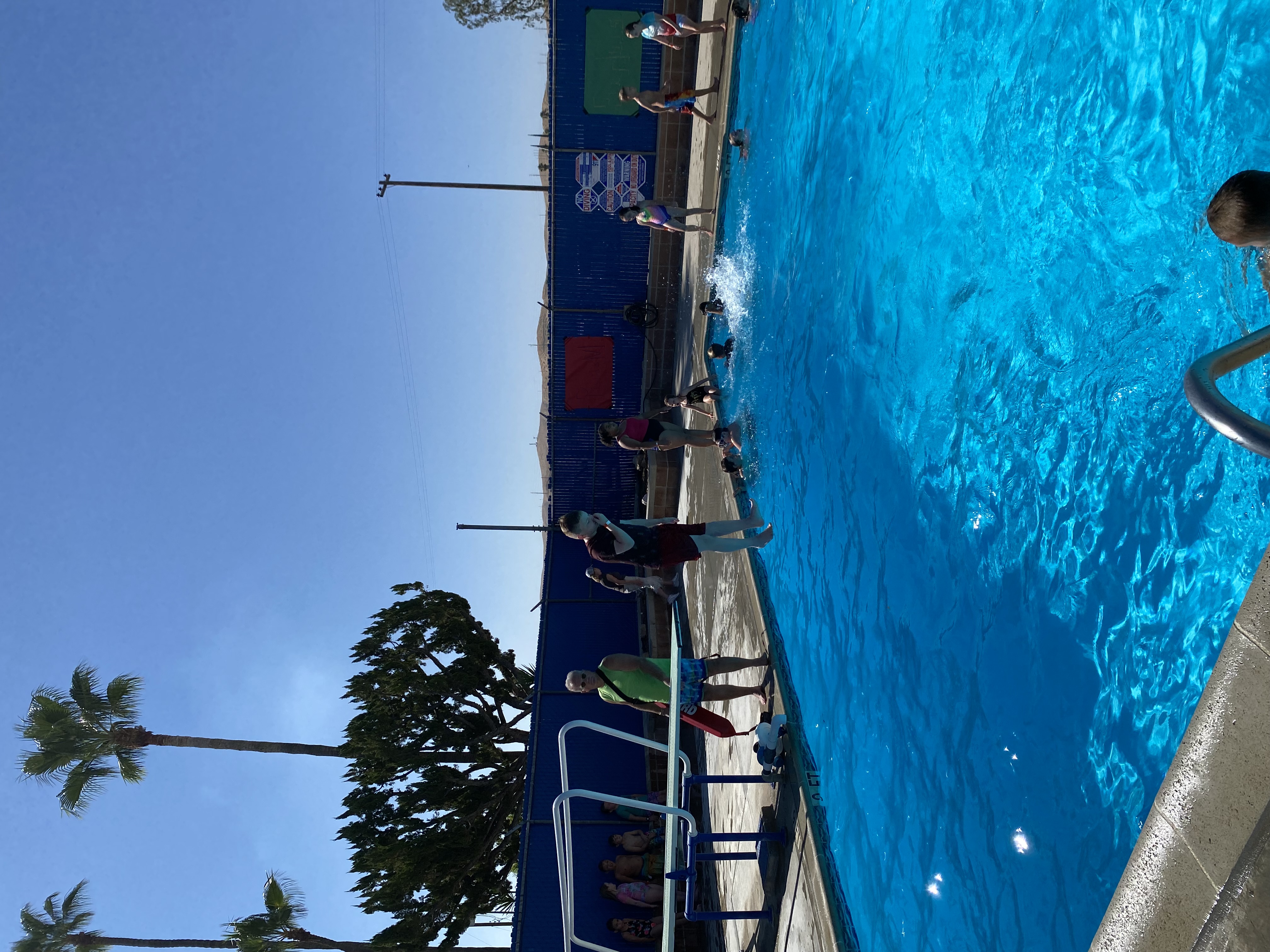 Student jumping off diving board into pool