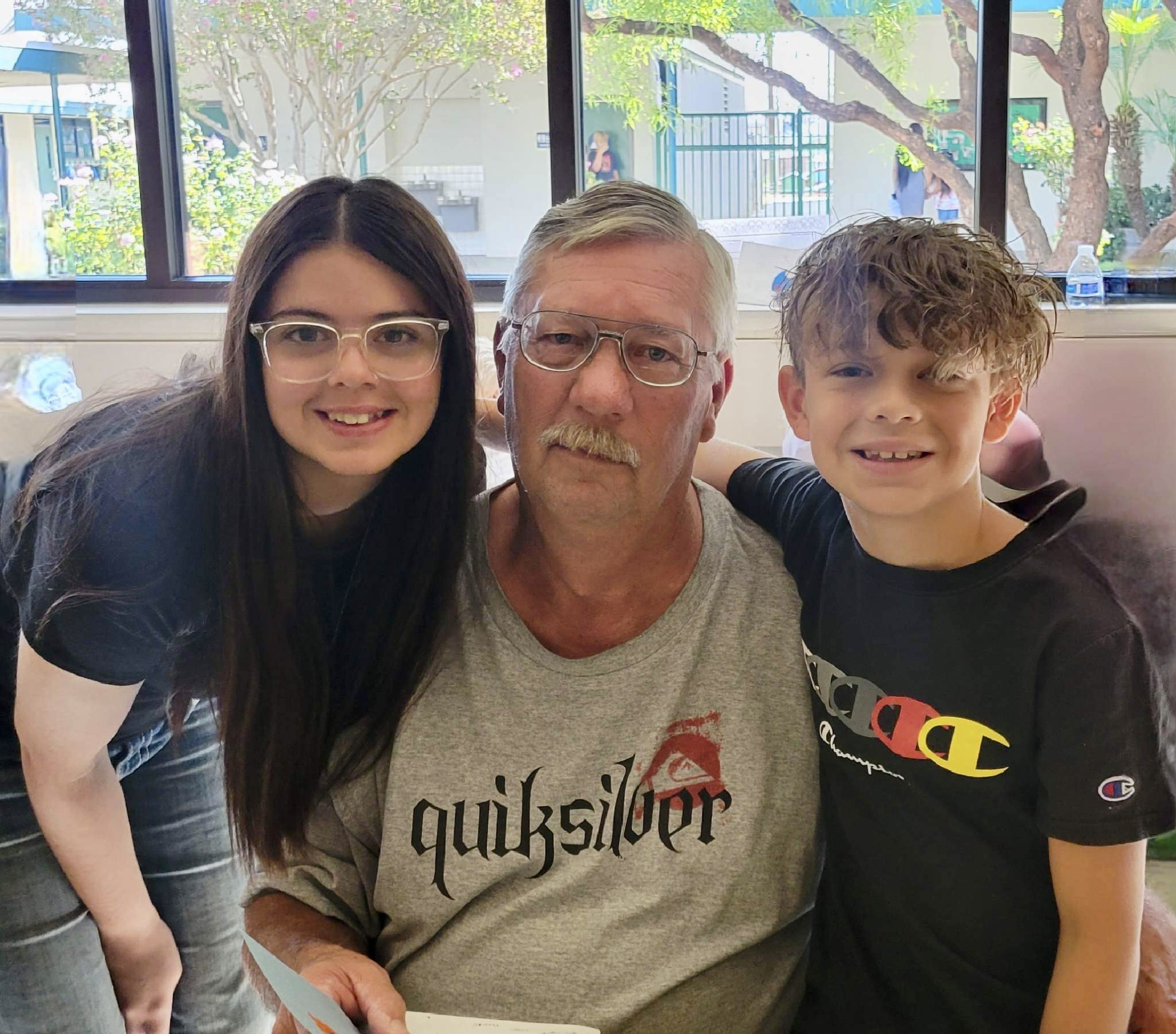 Two students with Grandpa during Grandparents' Day celebration