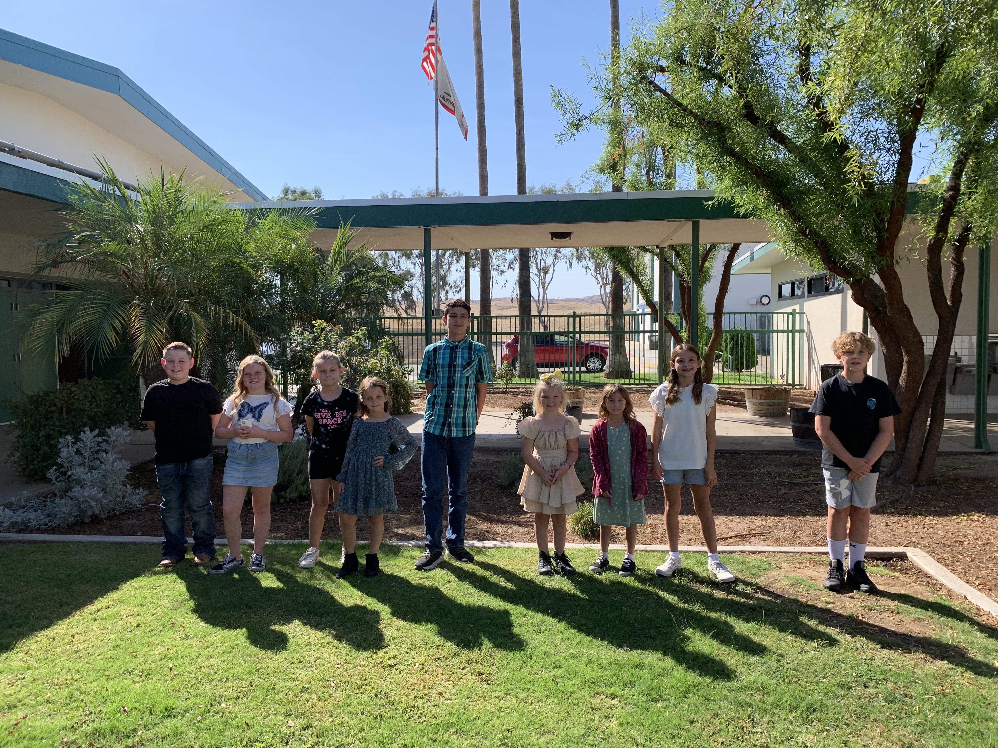 September Elk of the Month recipients stand in garden in front of the office