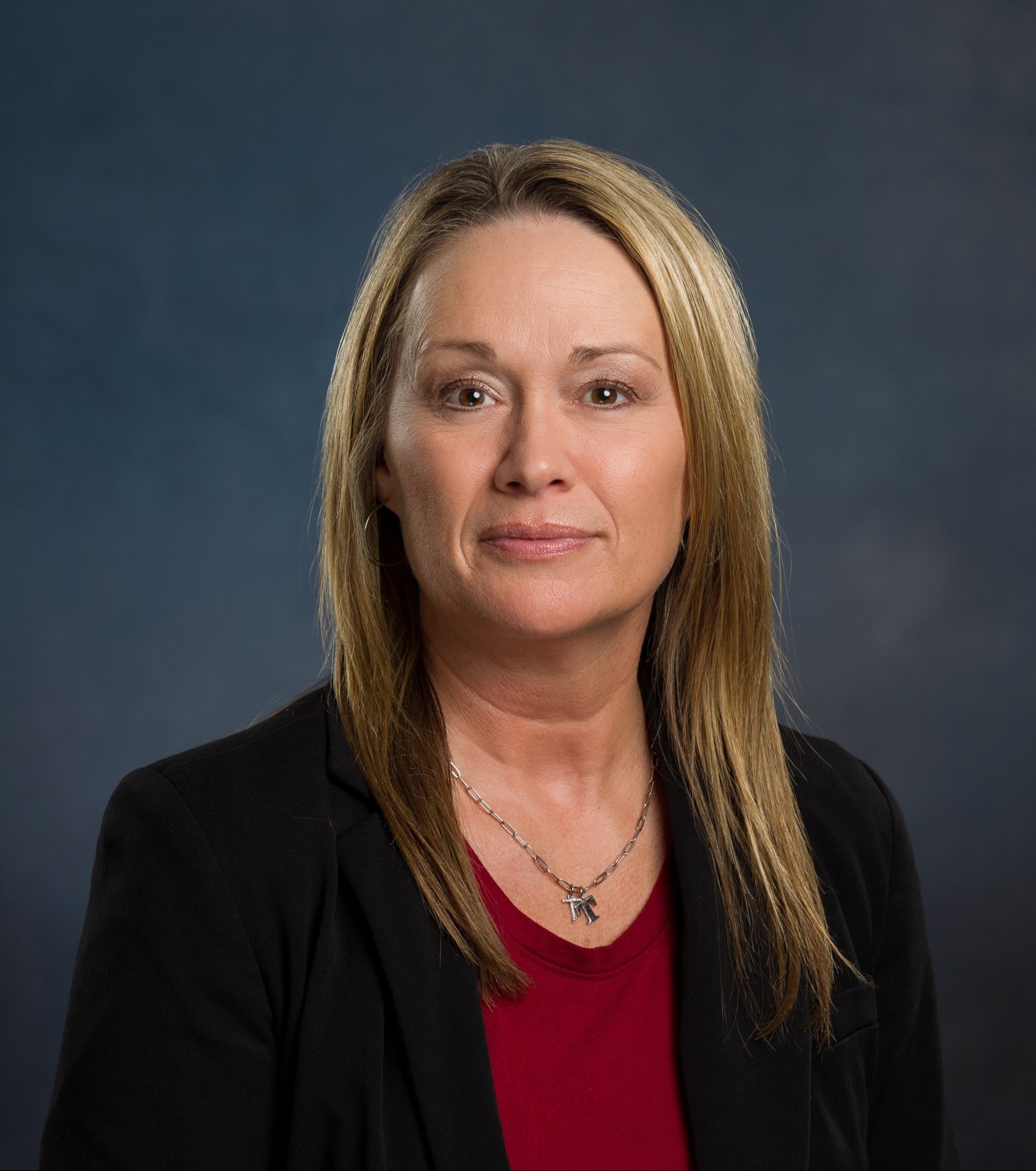 Tonya Phillips headshot, dark blonde hair wearing a red shirt with black blazer