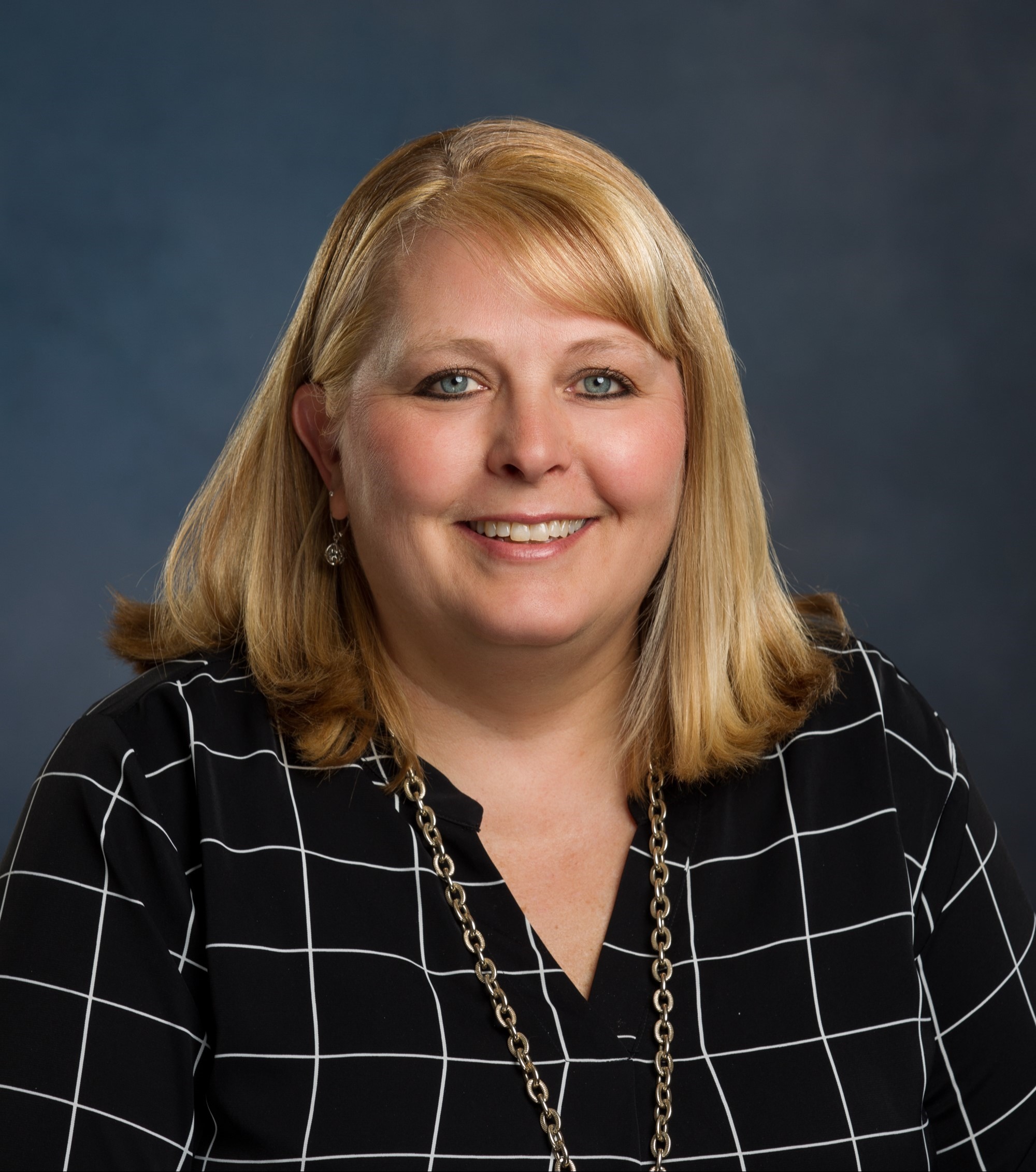 Stephanie Shupe headshot wearing black shirt with white stripes