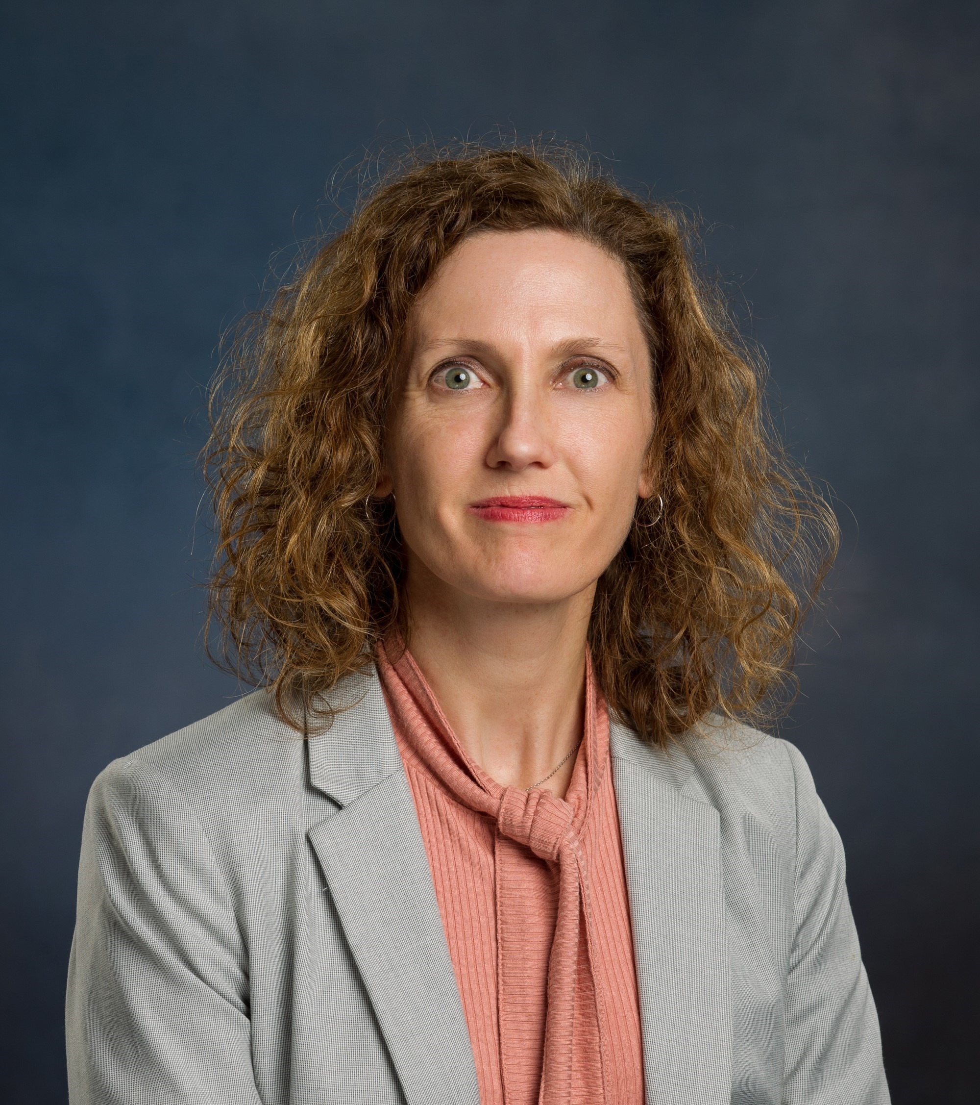 Audra Boone headshot wearing a pink top with gray blazer