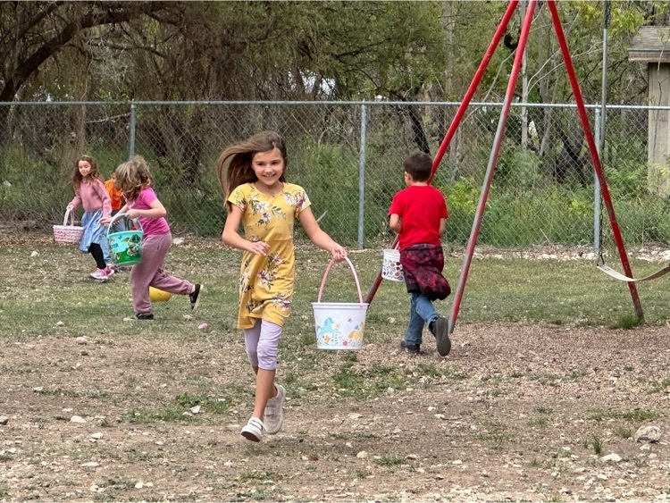 a young girl runs through the playground with an Easter basket in hand